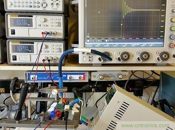 圖3：用于DC/DC轉換器的完整儀器設置展示。測試板輸入電壓調(diào)節(jié)至12V，柵極驅動調(diào)節(jié)器供電電壓為7V。右下方顯示了負載，Keysight 90000-X示波器、Teledyne Lecroy PP066傳輸線探頭和Huber Suhner Sucoflex 100電纜等也都可以在圖上看見。